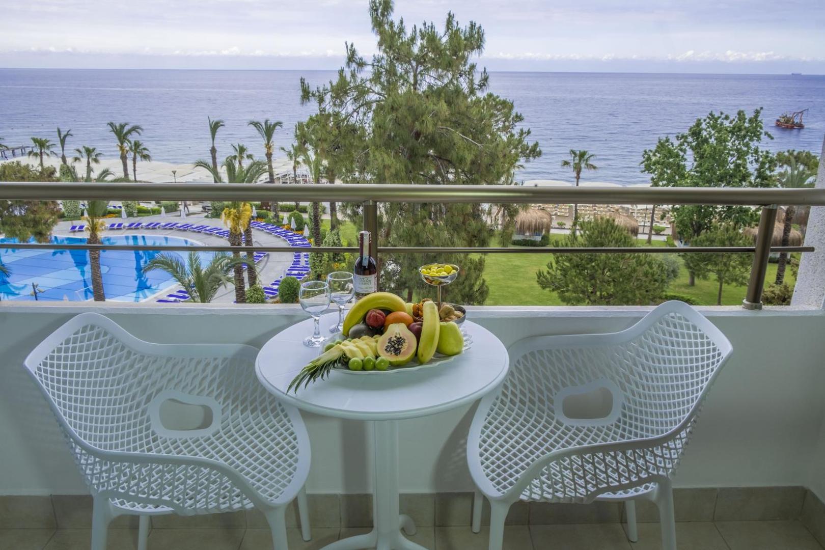 Skats no Mirada Del Mar Hotel balkona uz Vidusjūru, baseinu un dārzu ar augļu plati priekšplānā
