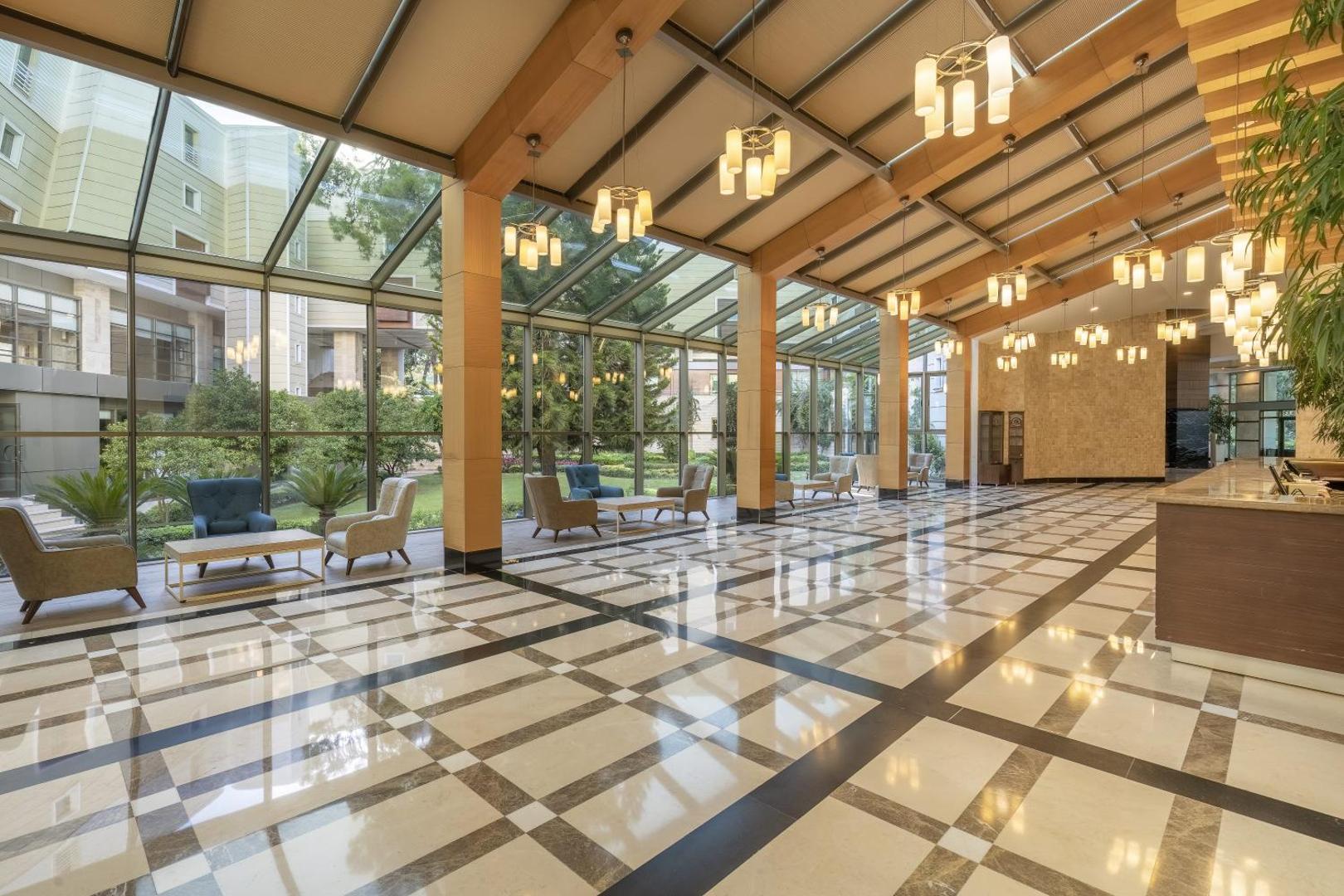 Mirada Del Mar Hotel plašais un gaišais vestibils ar stikla sienām, marmora grīdu un ērtām atpūtas zonām Kemeras piekrastē