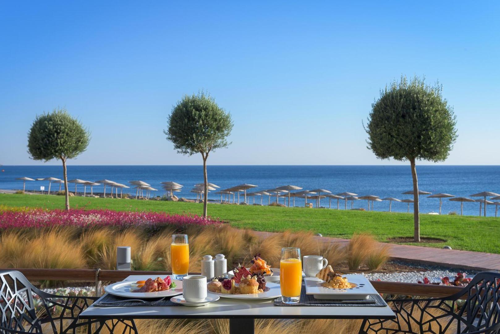 Brokastis uz Elysium Resort & Spa terases ar skatu uz jūru, svaigu apelsīnu sulu, kafiju un uzkodām saulainā rītā