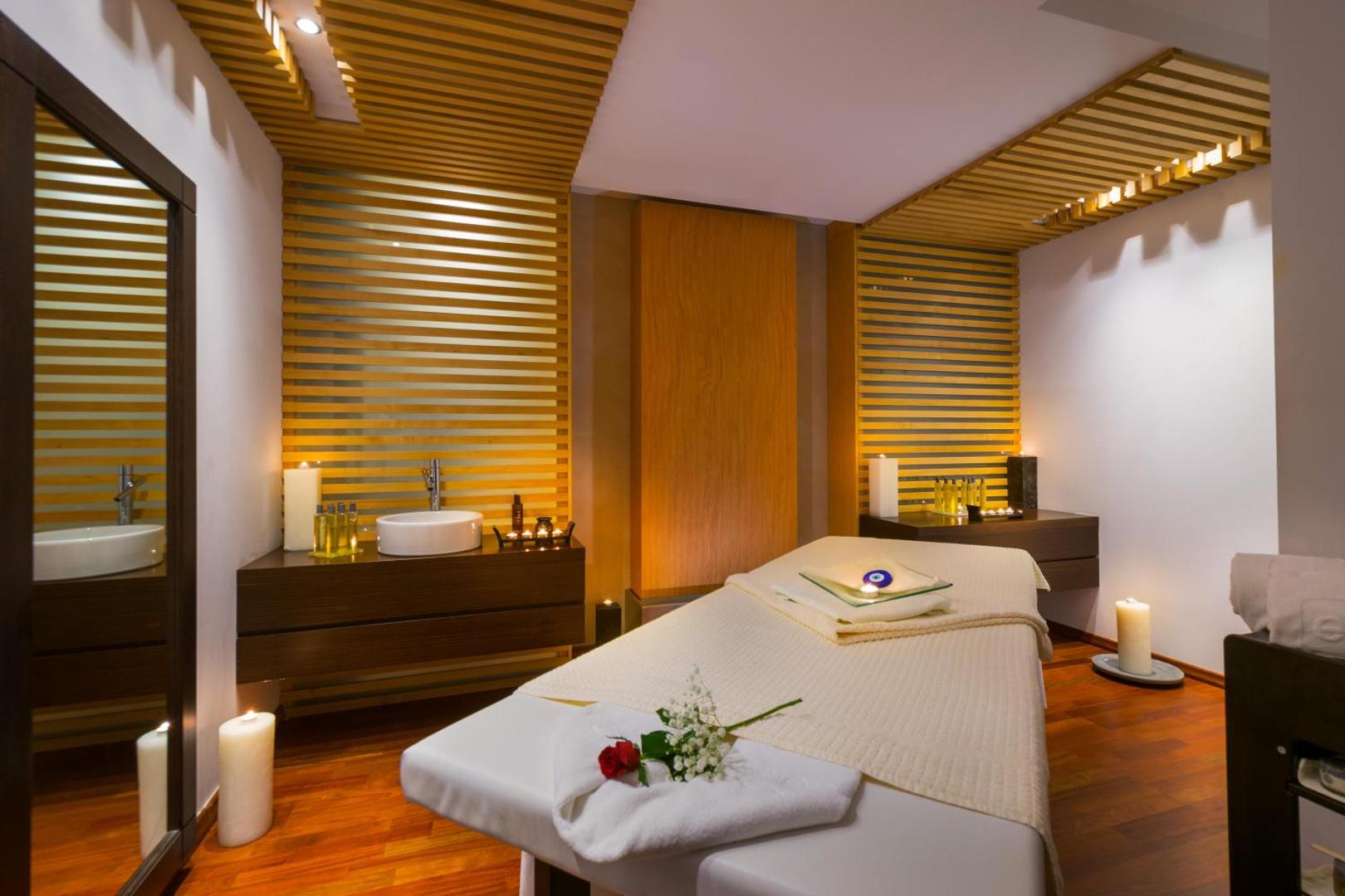 Elysium Resort & Spa mājīga masāžas telpa ar koka elementiem, svecēm un relaksējošu gaisotni spa centrā Rodas salā
