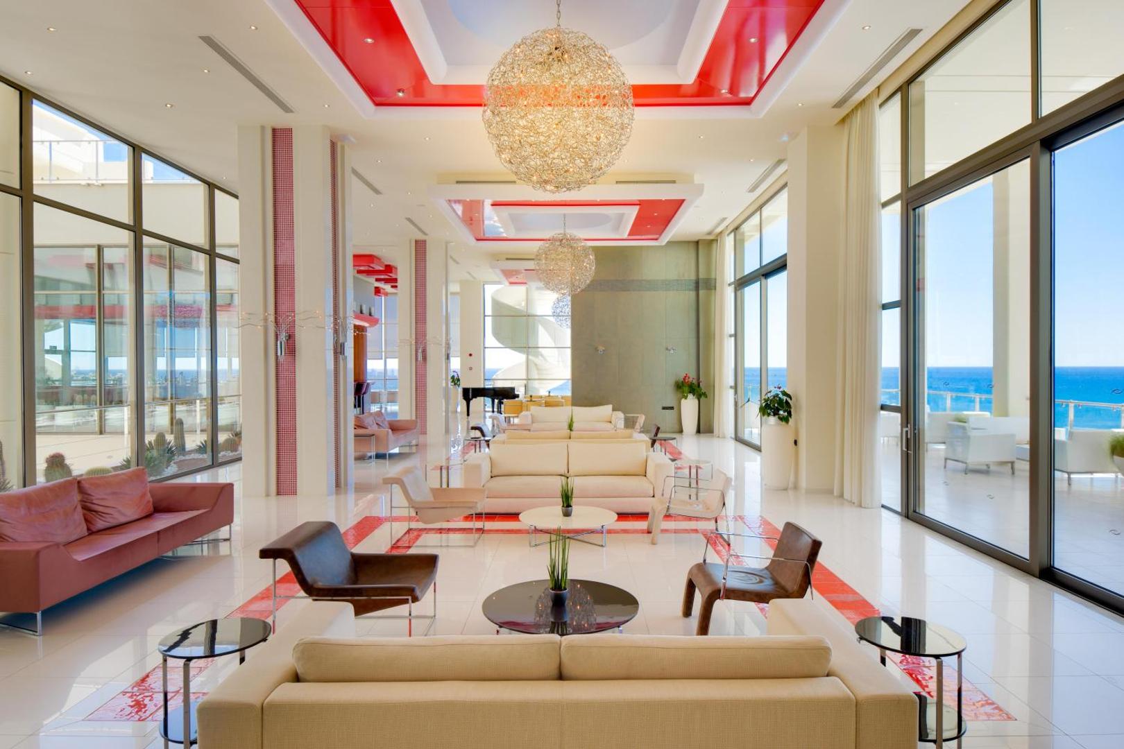 Elysium Resort & Spa plašais lobby bārs ar modernu dizainu, augstiem griestiem un panorāmas logiem uz jūru