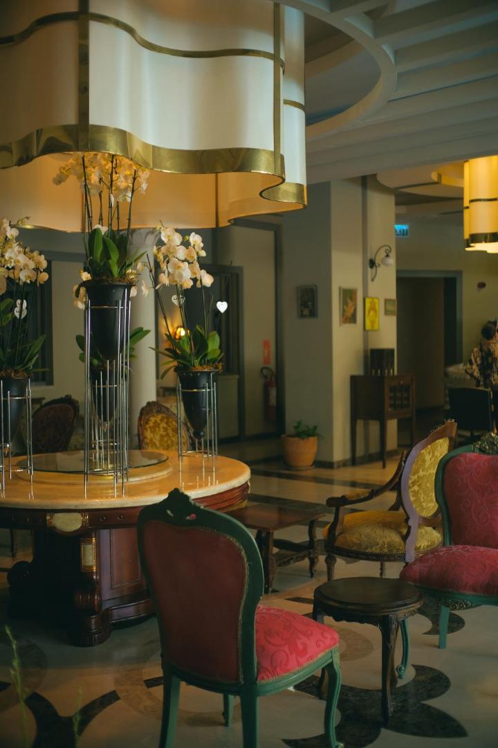 Castival Hotel atpūtas zona ar klasiska stila mēbelēm, ziedu kompozīcijām un mājīgu apgaismojumu viesu ērtībām viesnīcas iekštelpās