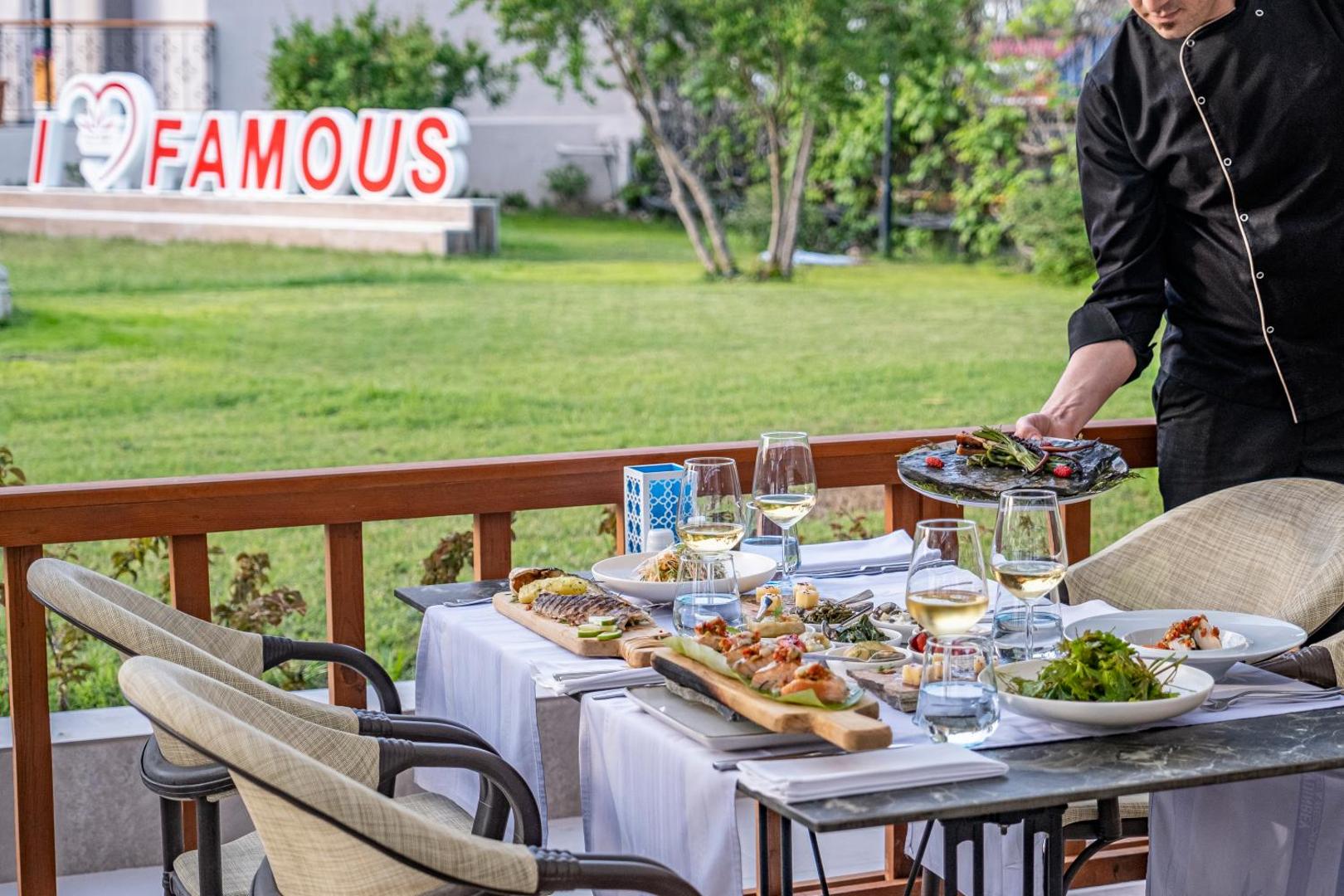 Aydinbey Famous Resort a la carte restorāna servējums uz terases ar jūras veltēm un vīnu dārza fonā