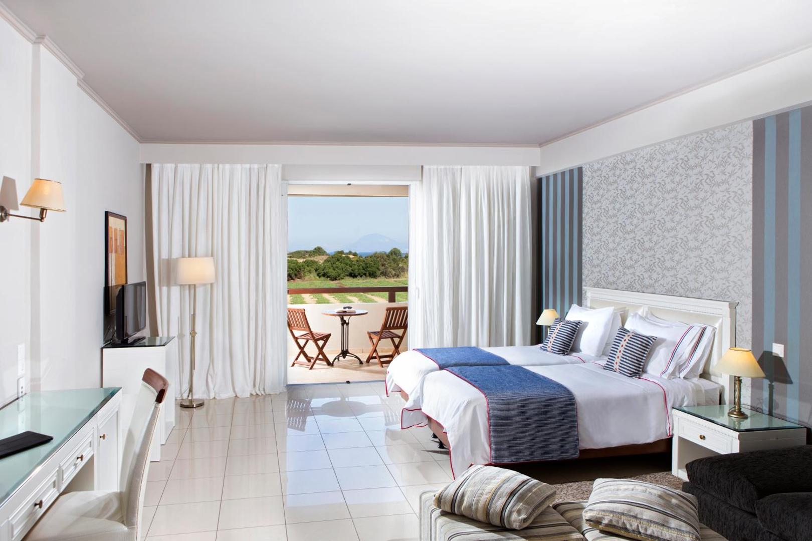 Olympia Golden Beach Resort & Spa numurs ar divām gultām un balkonu, no kura paveras skats uz Peloponēsas dabu