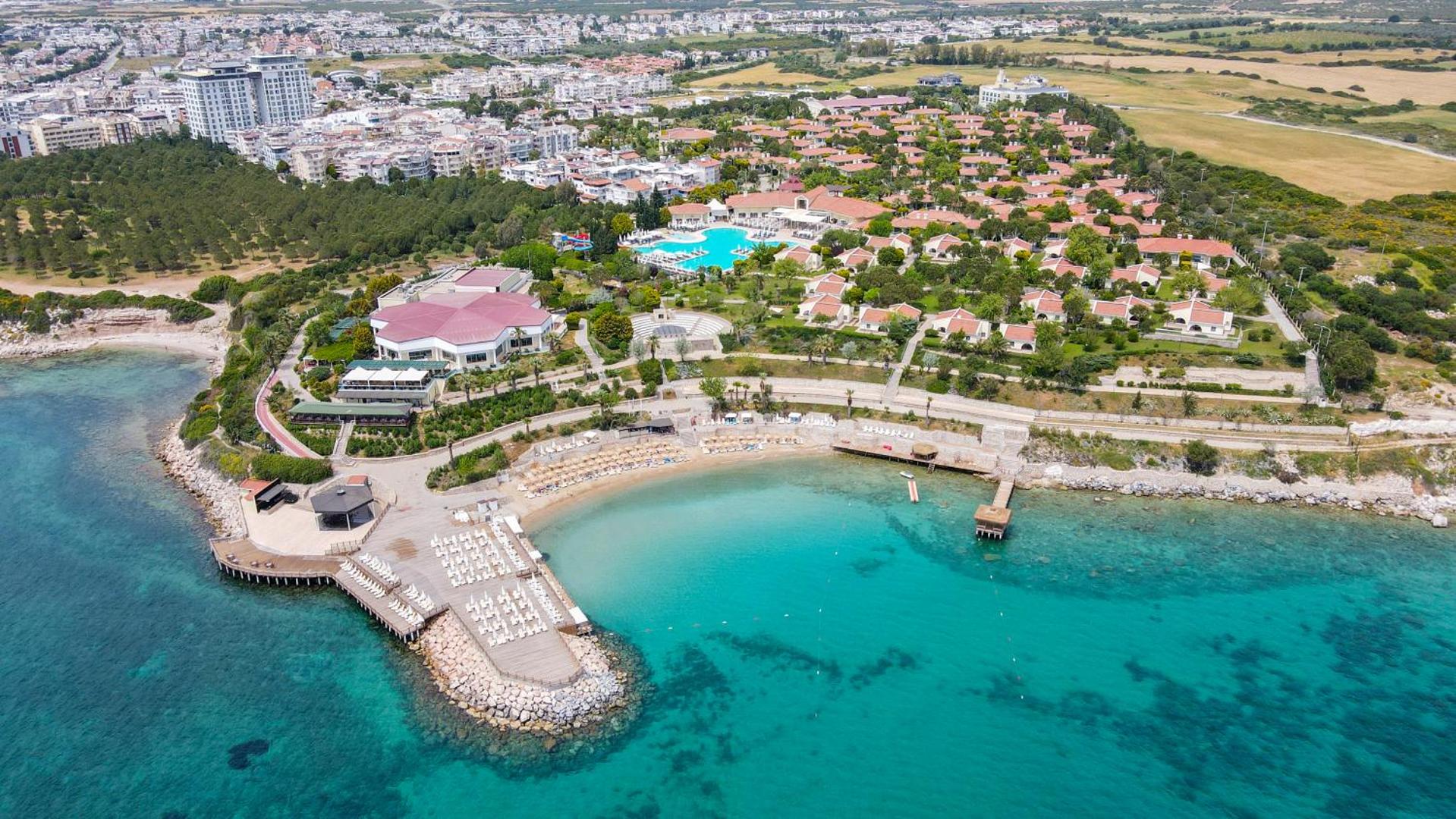 Anadolu Hotels Didim Club aerofoto uzņēmums Didimā, Turcijā — viesnīcas komplekss pie tirkīzzila līča ar privātu pludmali, baseiniem un bungalo tipa numuriem