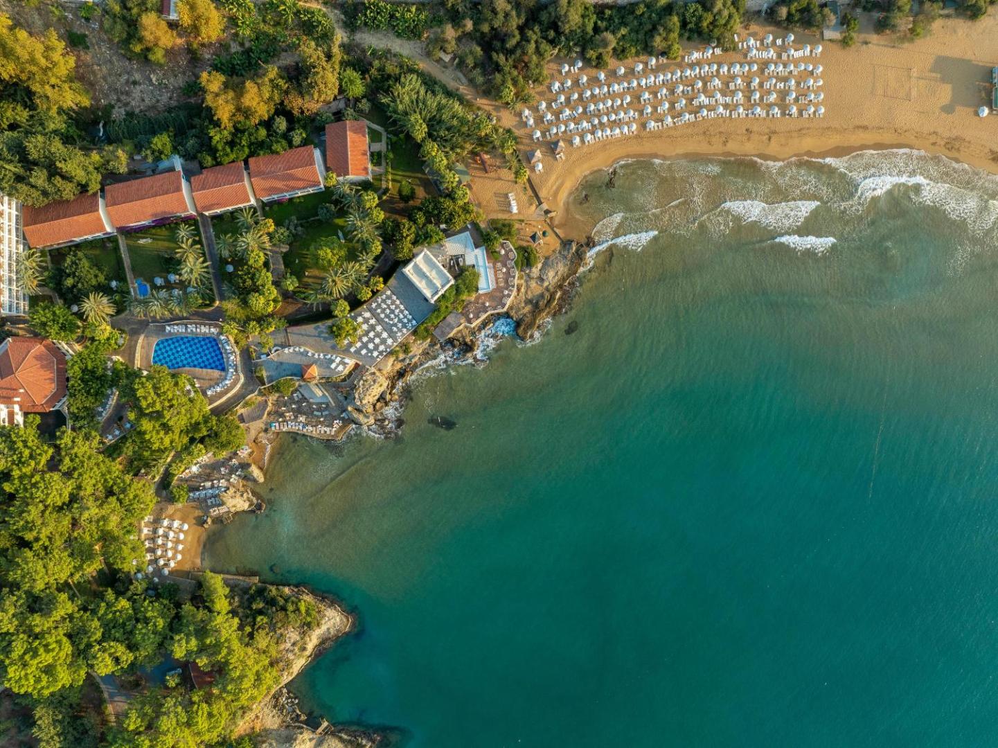 Utopia Beach Club viesnīcas skats no putna lidojuma Alanjā — privātā smilšu pludmale, tirkīza krāsas jūra, āra baseins un dārza teritorija