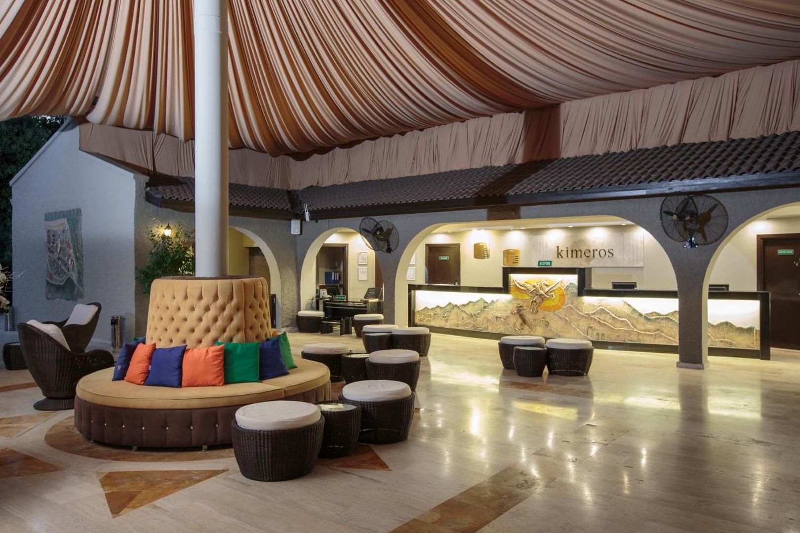 Kimeros Park Holiday Village plašā recepcijas zona ar stilīgu atpūtas dīvānu un dekoratīviem griestu audumiem Kemeras reģionā, Turcijā
