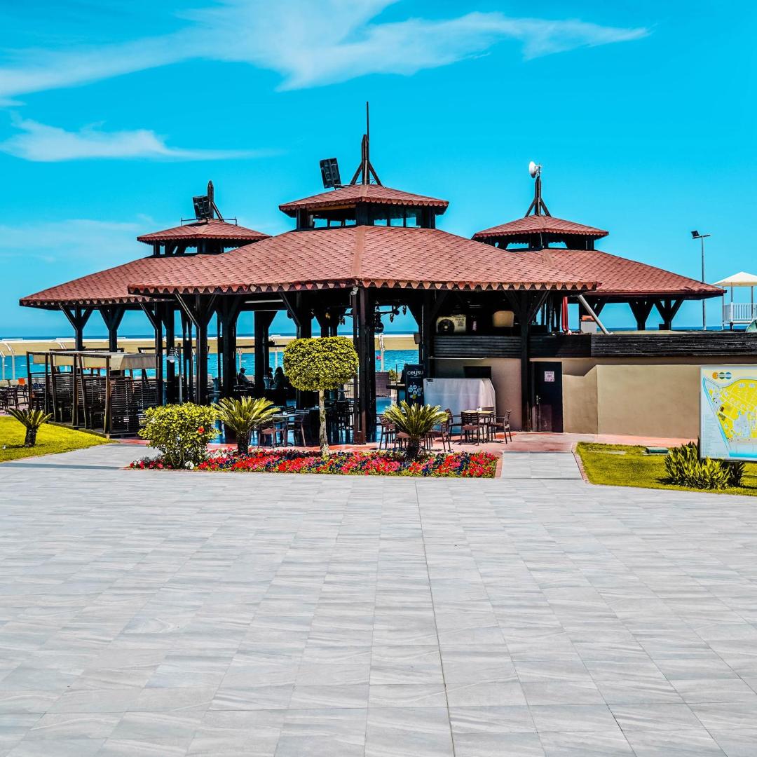 Kimeros Park Holiday Village koka arhitektūras bārs ar terasi un ziedu dobēm viesnīcas dārza teritorijā