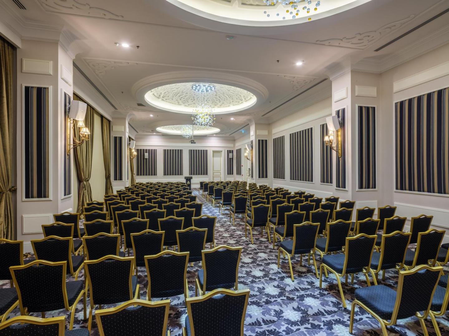 Plaša un grezna konferenču zāle viesnīcā Rubi Platinum SPA Resort & Suites ar klasisku interjeru un mīkstajiem krēsliem