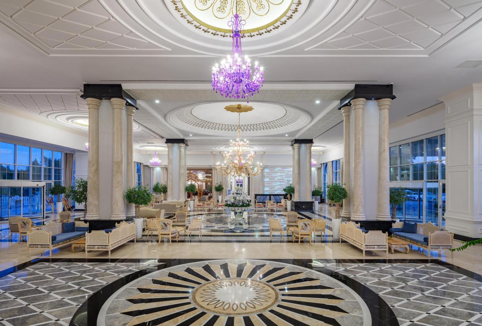 Rubi Platinum SPA Resort & Suites greznais vestibils ar augstiem griestiem, marmora grīdu un iespaidīgām lustrām Alānijas reģionā