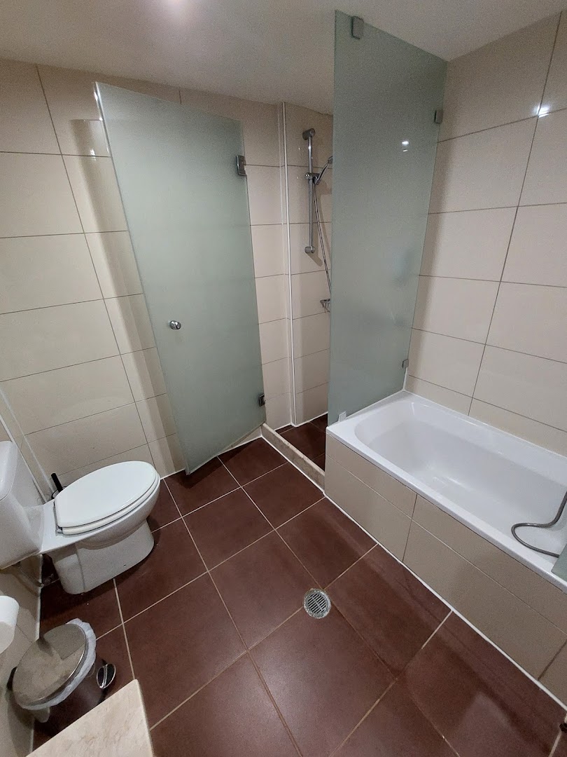 Koutrakis Suites by Estia numura vannasistaba Sisī, Krētā — gaišas flīzes, vanna, atsevišķa dušas zona ar matēta stikla durvīm un tualete