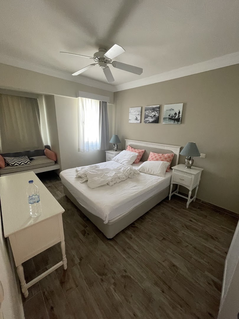 Paloma Marina Suites guļamistaba ar griestu ventilatoru un koka faktūras grīdu — mājīgs numurs Kušadasi pilsētā