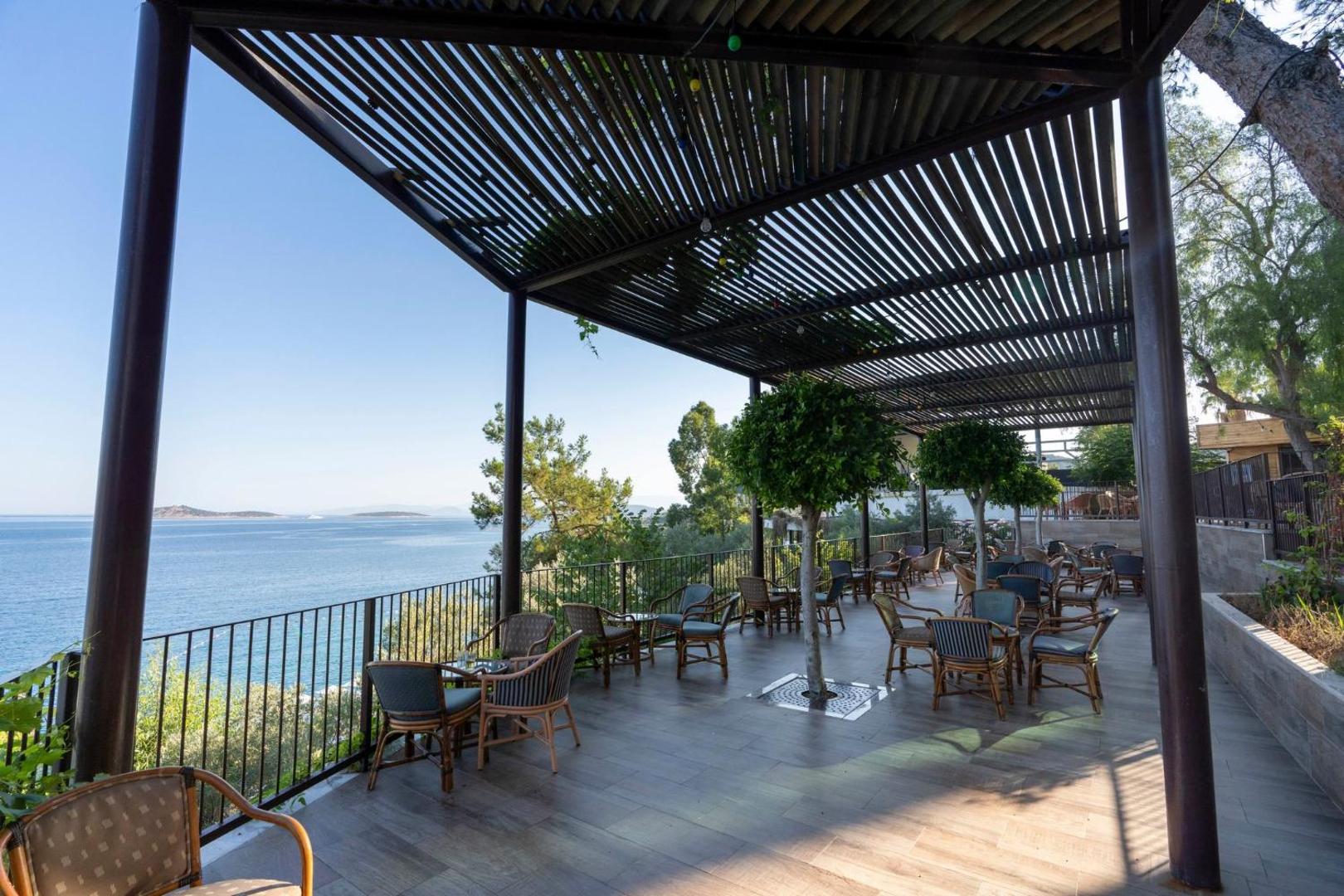 Viesnīcas Blue Dreams Resort & Spa plašā āra terase ar modernām mēbelēm zem nojumes un skatu uz jūru