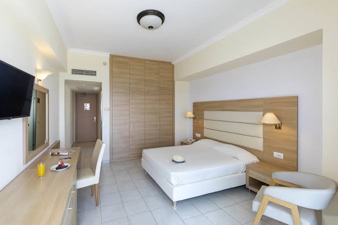Plašs Belair Beach viesnīcas numurs Rodā ar atpūtas zonu, TV un lielu skapi — skats uz ieeju un darba zonu