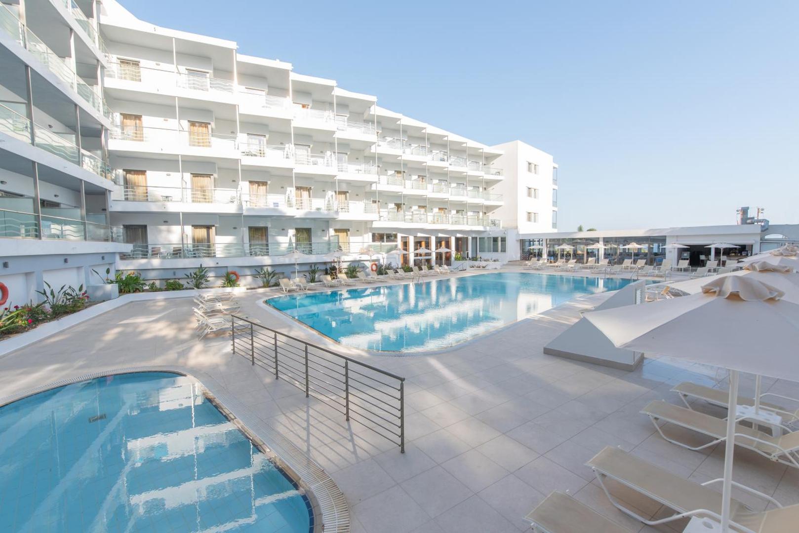 Belair Beach viesnīcas balta modernā ēka ar balkoniem un diviem āra baseiniem Rodas piekrastē Grieķijā