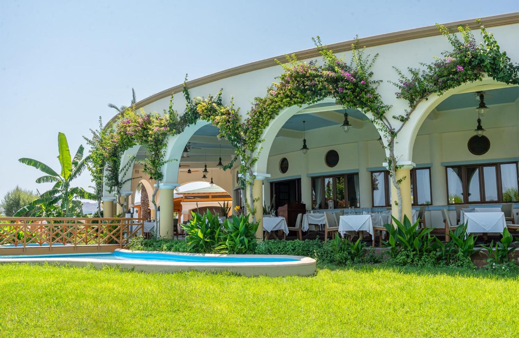 Atrium Palace Thalasso Spa Resort And Villas ēdienkartes restorāna terase ar arkām un ziedošiem augiem Rodas salas kūrortā
