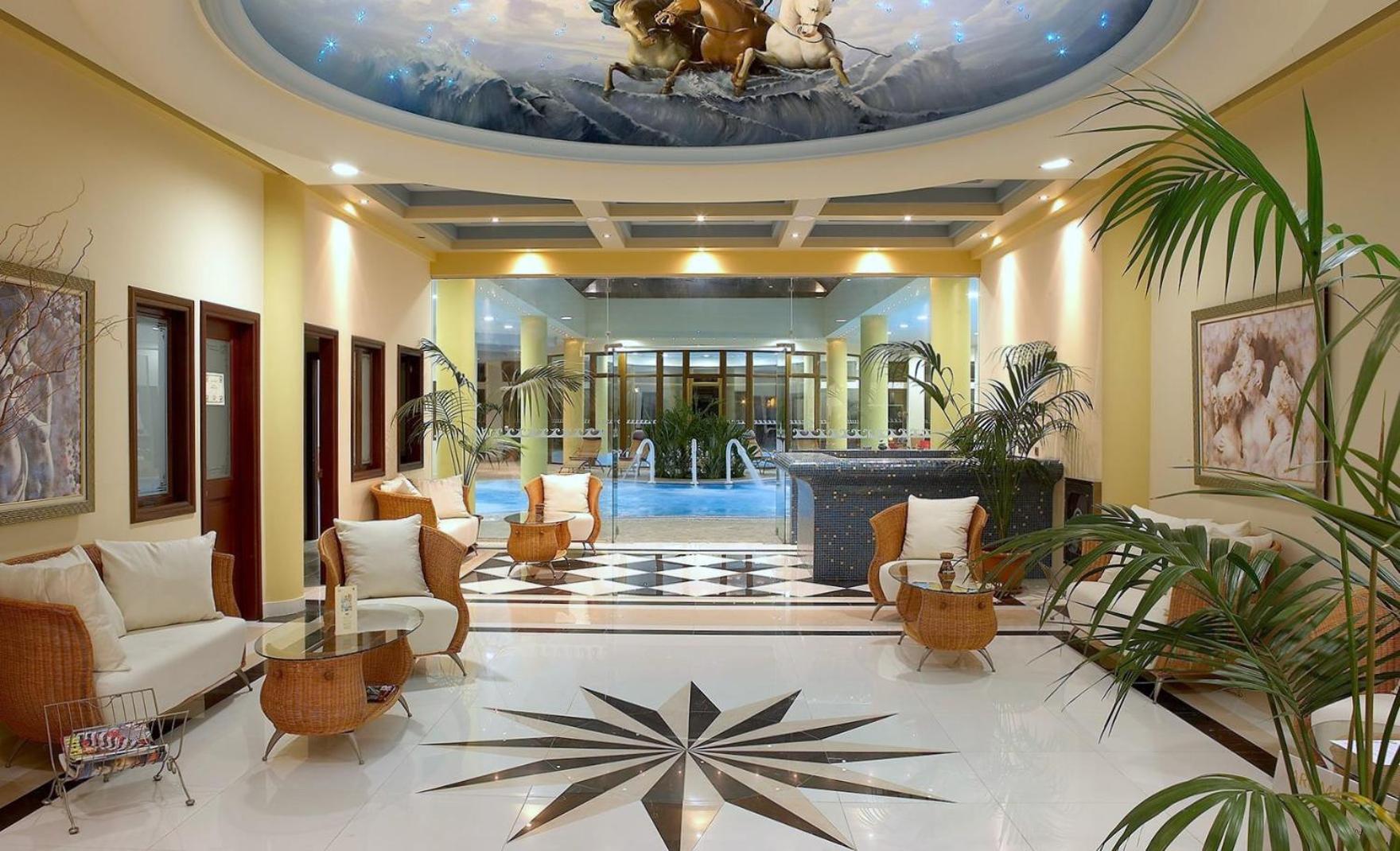 Atrium Palace Thalasso Spa Resort elegantais vestibils ar marmora grīdām, pītiem krēsliem un skatu uz spa zonu