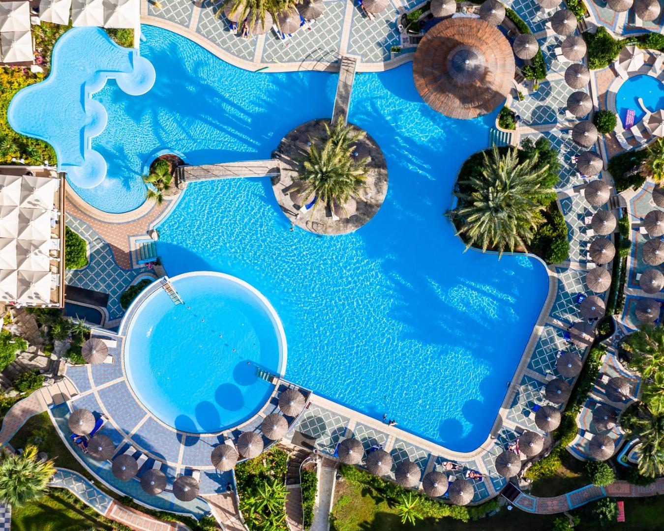 Atrium Palace Thalasso Spa Resort And Villas baseinu komplekss no putna lidojuma Rodā ar tiltiņiem, salām un saulessargu zonām