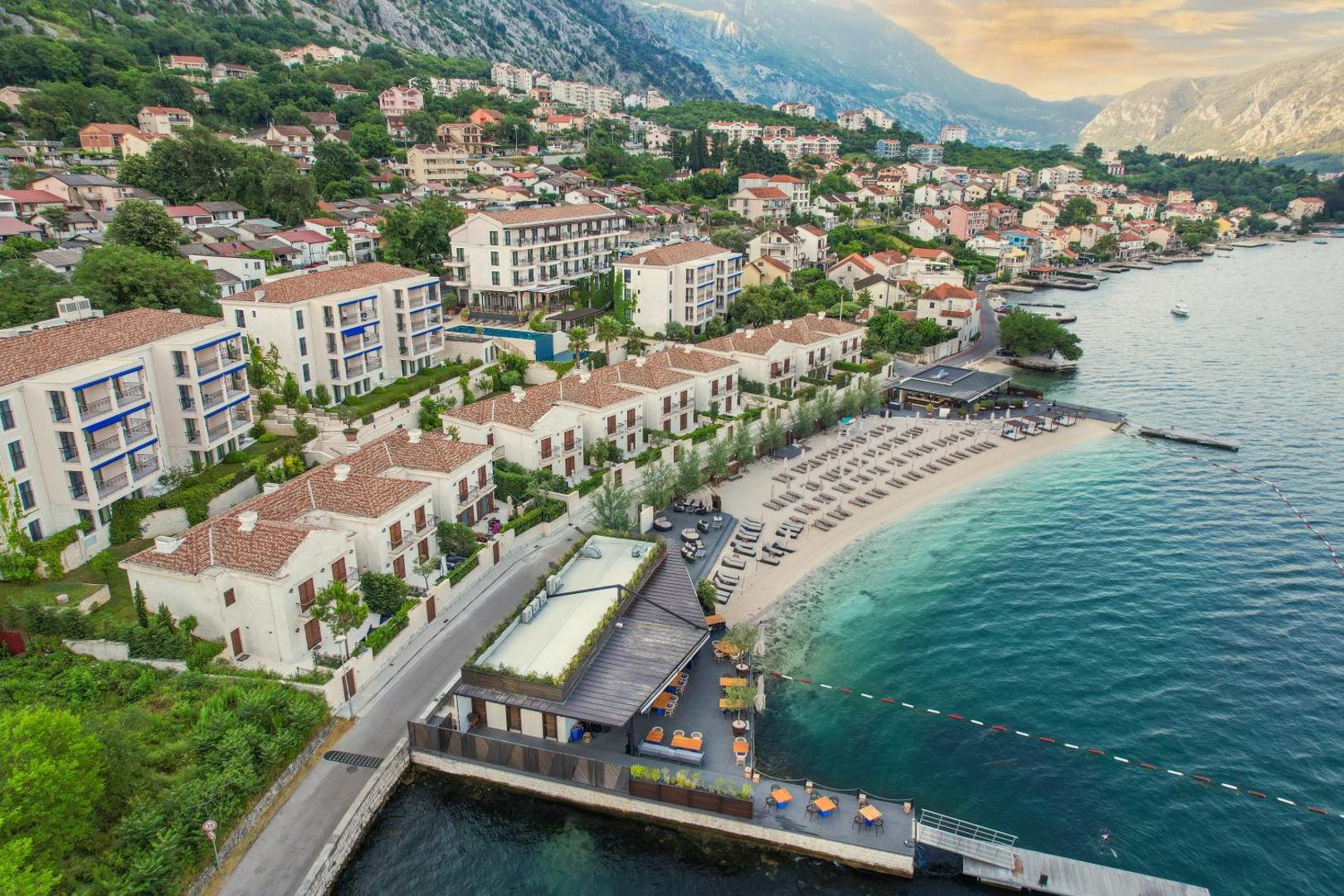 HUMA Kotor Bay Hotel & Villas skats no putna lidojuma uz piekrasti, privāto pludmali un kalnu fonu Melnkalnē