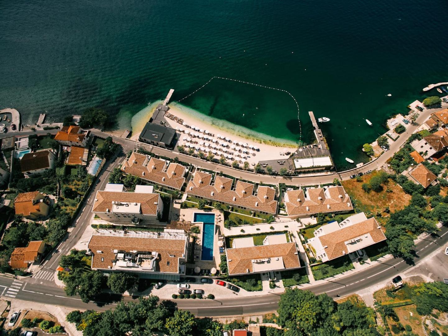 HUMA Kotor Bay Hotel & Villas teritorijas plānojums no augšas ar baseinu, ēku kompleksu un pludmales zonu