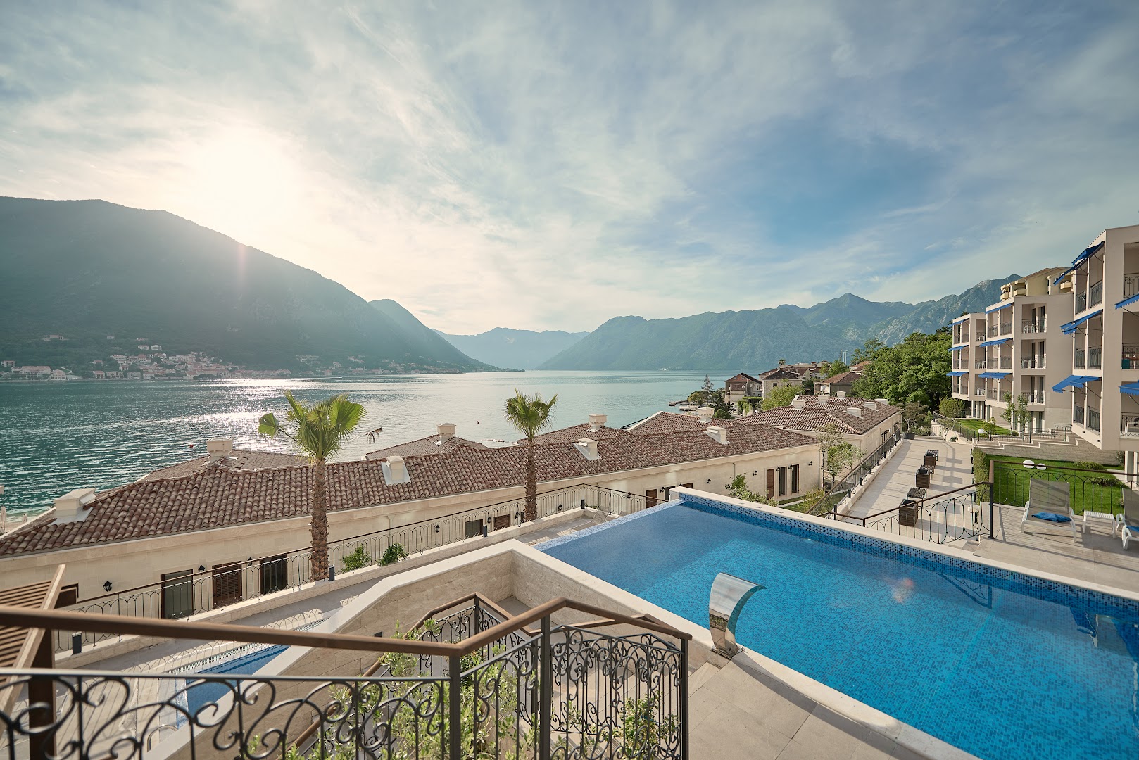 HUMA Kotor Bay Hotel & Villas kompleksa skats no augšas ar baseinu, villu jumtiem un Kotoras līča piekrasti