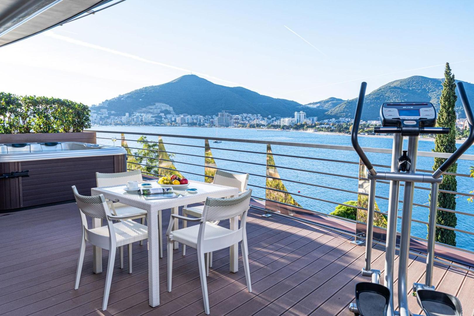 Dukley Hotel & Resort privātā terase ar džakuzi, pusdienu galdu un trenažieri Budvā — skats uz kalniem un jūras līci
