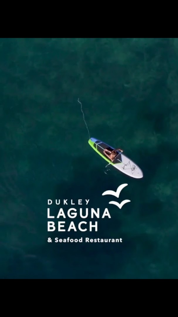 Skats no augšas uz SUP dēļa airētāju tirkīza zilā ūdenī pie Dukley Laguna Beach & Seafood Restaurant