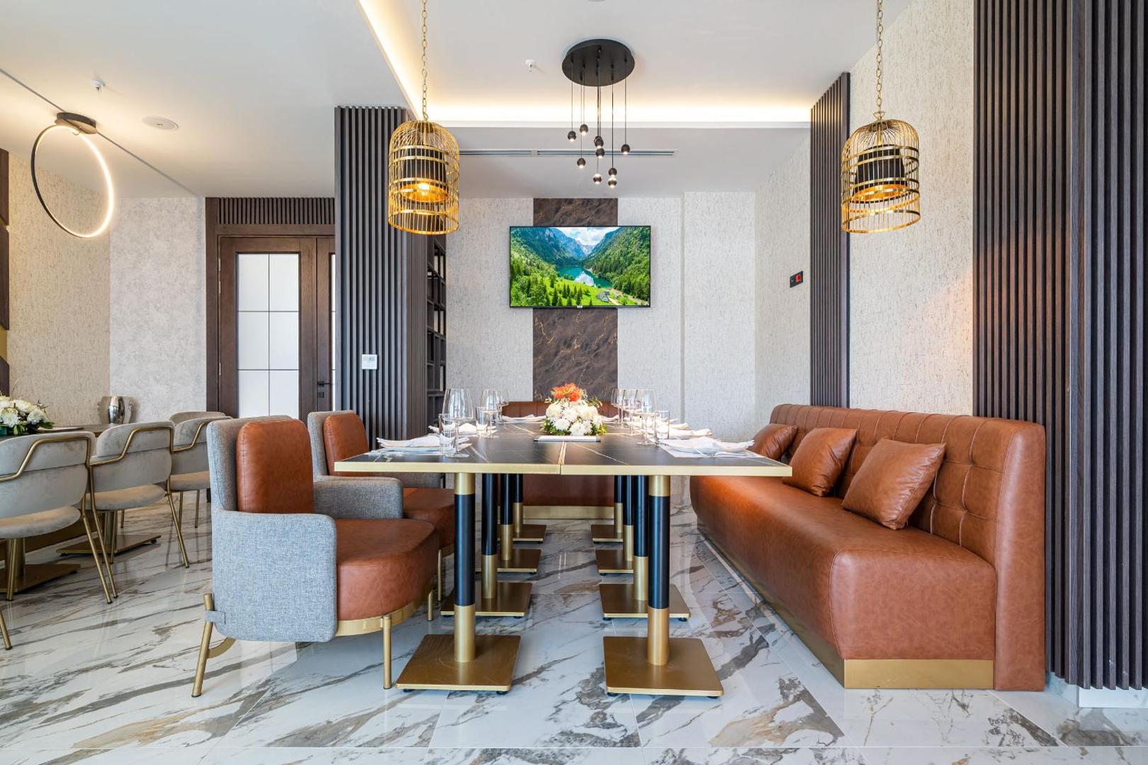 Hotel Millennium by Aycon restorāna zona ar ādas dīvāniem, marmora grīdu un modernu interjera dizainu