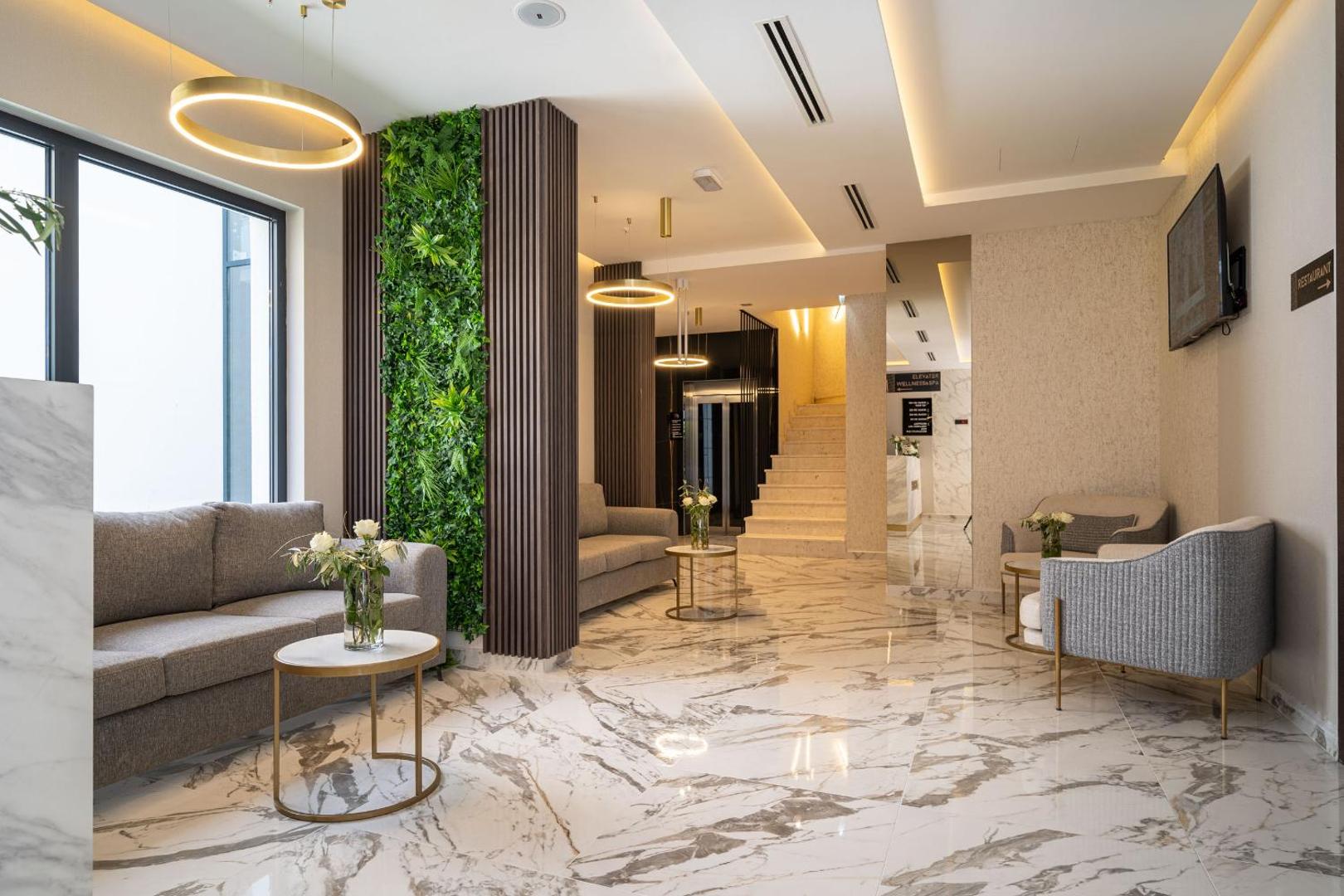 Viesnīcas Hotel Millennium by Aycon vestibils ar ērtiem dīvāniem, marmora grīdu un dekoratīviem augu paneļiem atpūtas zonā.