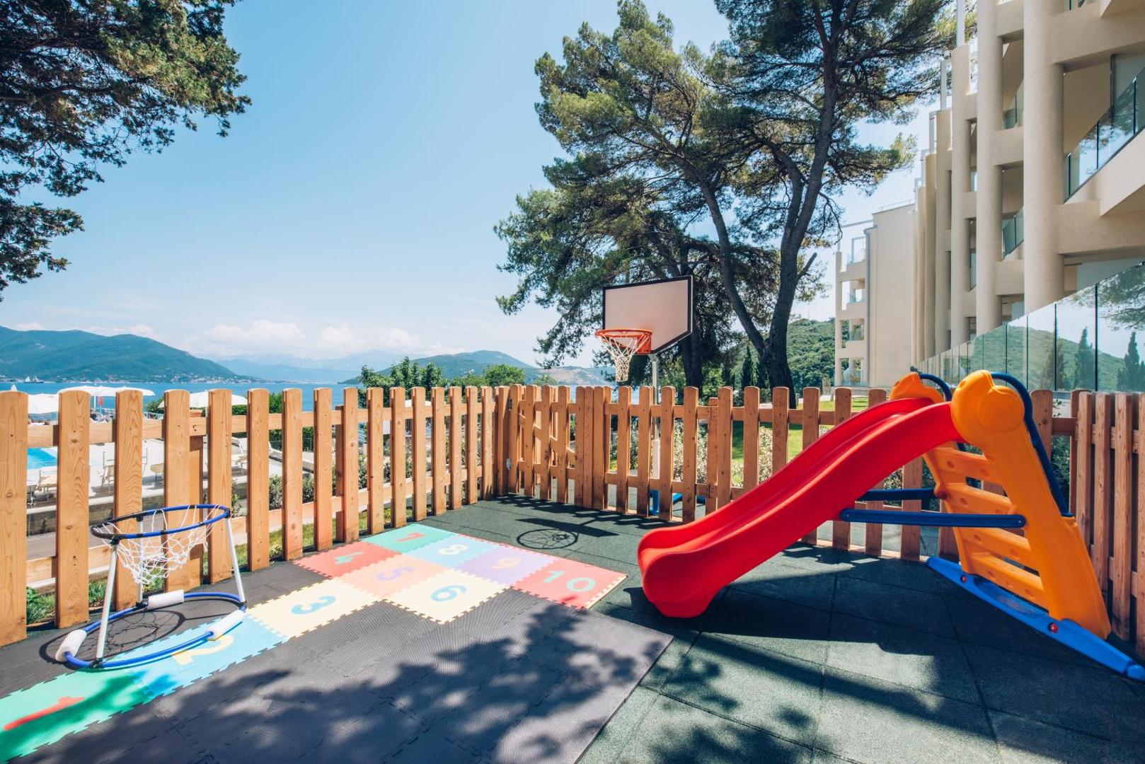 Iberostar Herceg Novi bērnu rotaļu laukums ar slidkalniņu, basketbola grozu un mīksto segumu piekrastes priežu ielokā