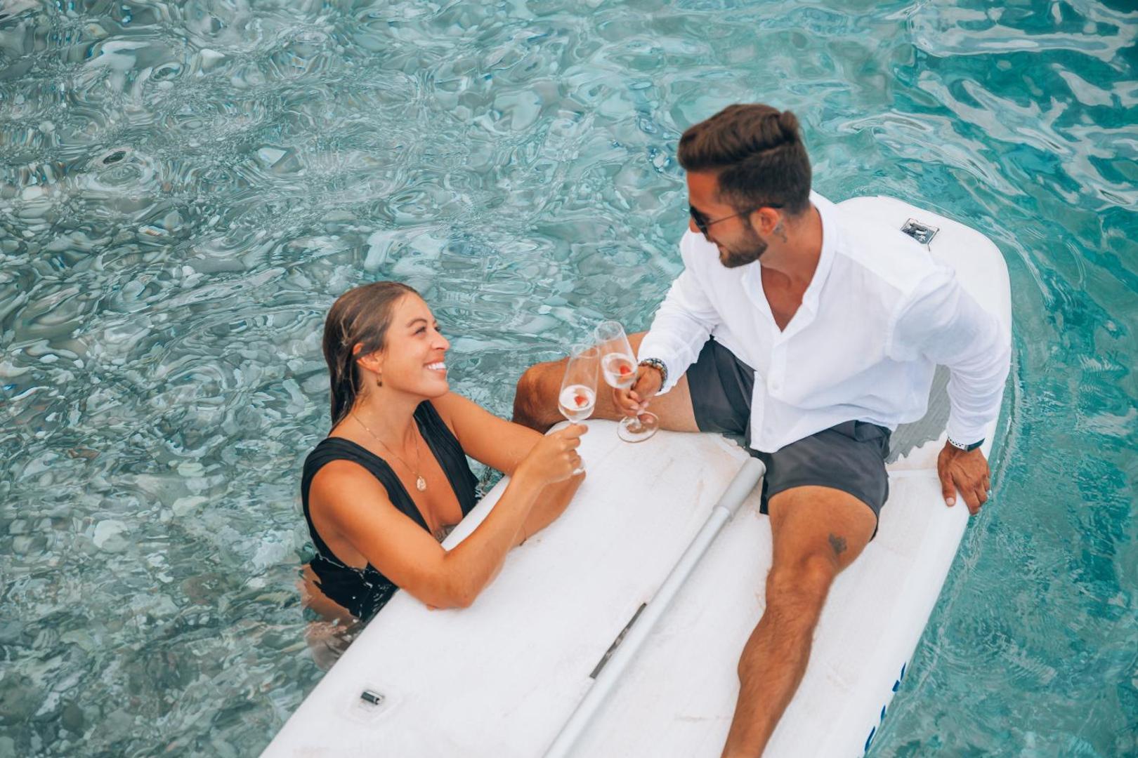 Pāris bauda dzērienus uz SUP dēļa kristāldzidrā Adrijas jūras ūdenī pie Boutique Hotel & Spa Casa del Mare krasta