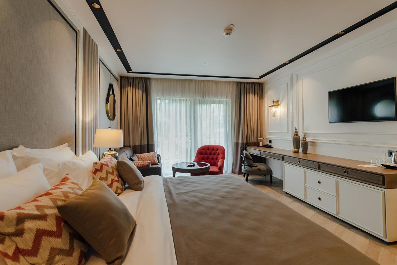 Boutique Hotel & Spa Casa del Mare numura interjers ar darba galdu, TV un ērtu gultu gaišos toņos