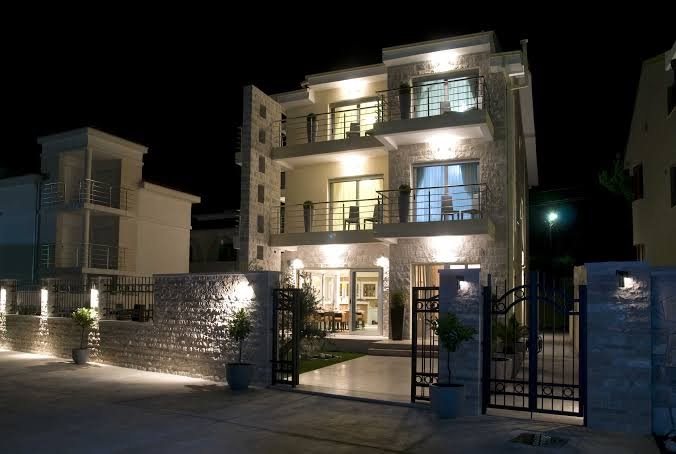 Boutique Hotel & Spa Casa del Mare ēka naktī ar izgaismotiem balkoniem, akmens sienām un dekoratīviem vārtiem