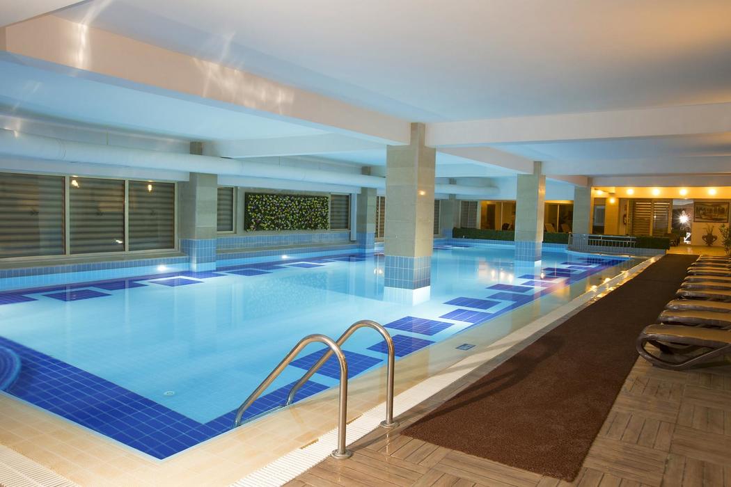 Fame Residence Kemer & Spa iekštelpu baseins ar apsildi un atpūtas krēsliem spa centrā relaksācijai jebkuros laikapstākļos