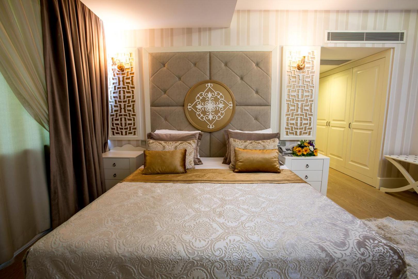 Fame Residence Kemer & Spa luksusa numura gulta ar greznu galvgali, rakstainu gultas pārklāju un siltu apgaismojumu