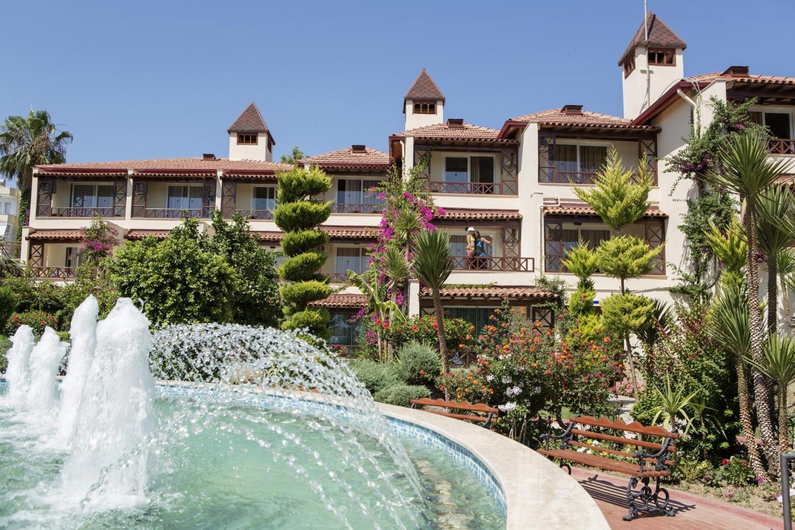 Saphir Hotel & Villas villas tipa numuri ar terasēm, ko ieskauj ziedoši krūmi, dekoratīvas strūklakas un sakopta parka zona