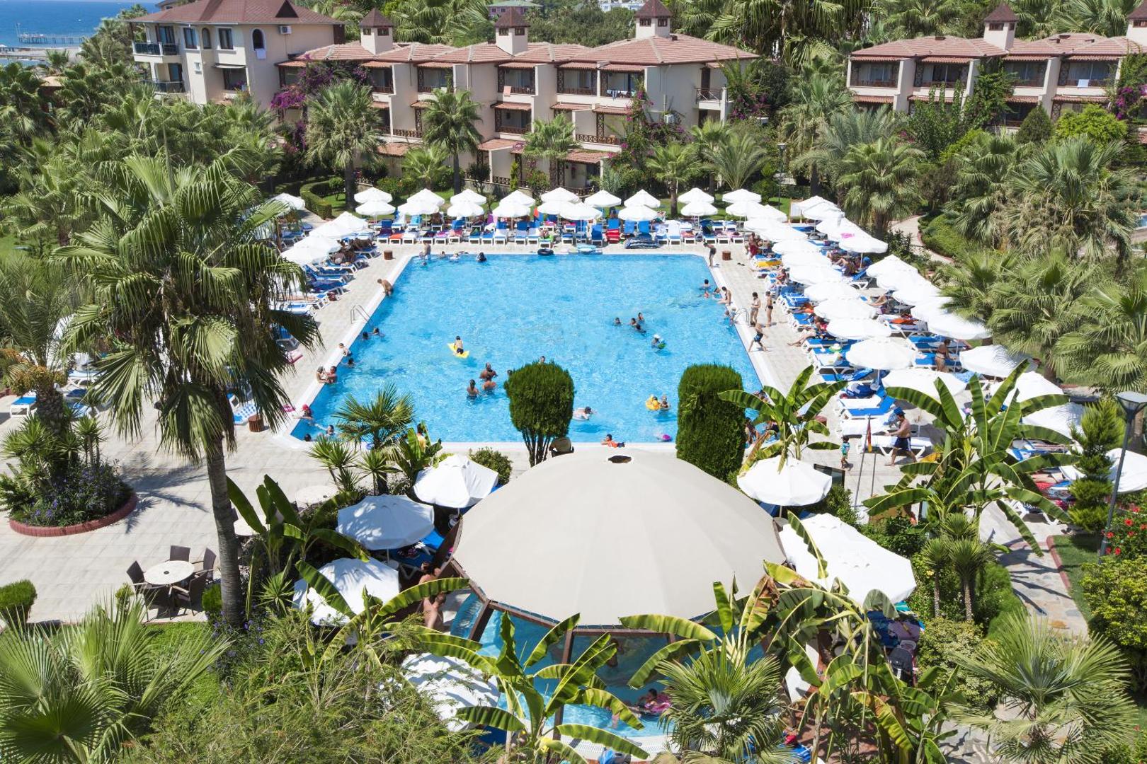 Saphir Hotel & Villas teritorija ar baseinu, villu korpusiem un blīvu palmu dārzu Alanjas piekrastē