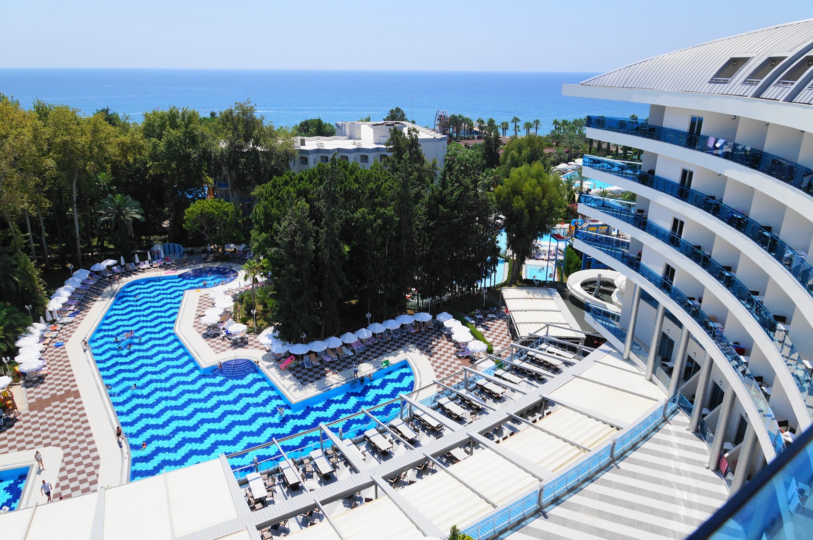 Botanik Hotel & Resort teritorijas skats no augšas uz baseiniem, dārzu un Vidusjūras piekrasti Alanjā