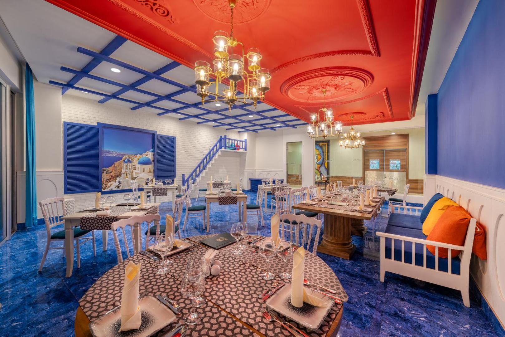 Botanik Hotel & Resort tematiskais restorāns ar grieķu stila interjeru — zilas grīdas, sarkani griesti un Santorini sienas gleznojums