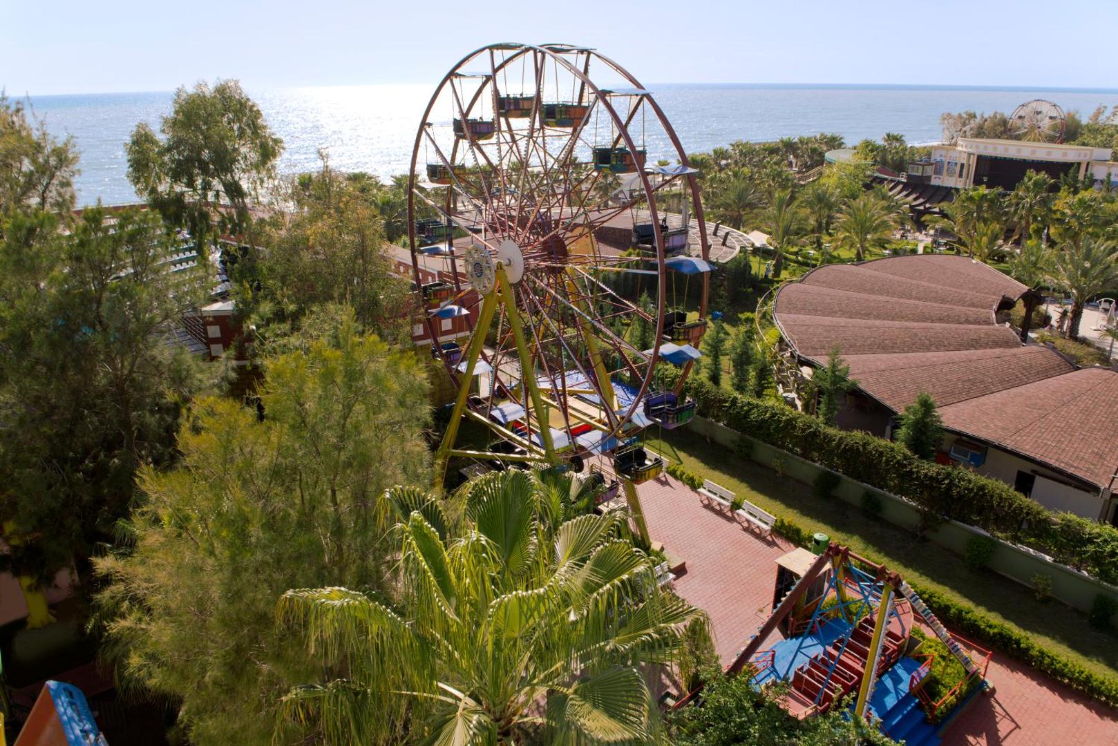 Botanik Hotel & Resort panorāmas skats uz atrakciju parku ar lielo panorāmas ratu piekrastē un Vidusjūras fonu
