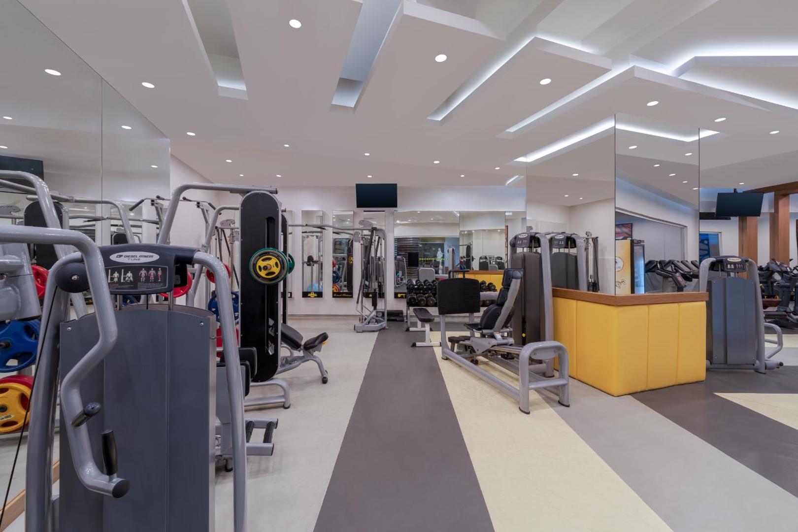 Botanik Hotel & Resort moderns fitness centrs ar trenažieriem, spoguļu sienām un gaišu apgaismojumu aktīvai atpūtai