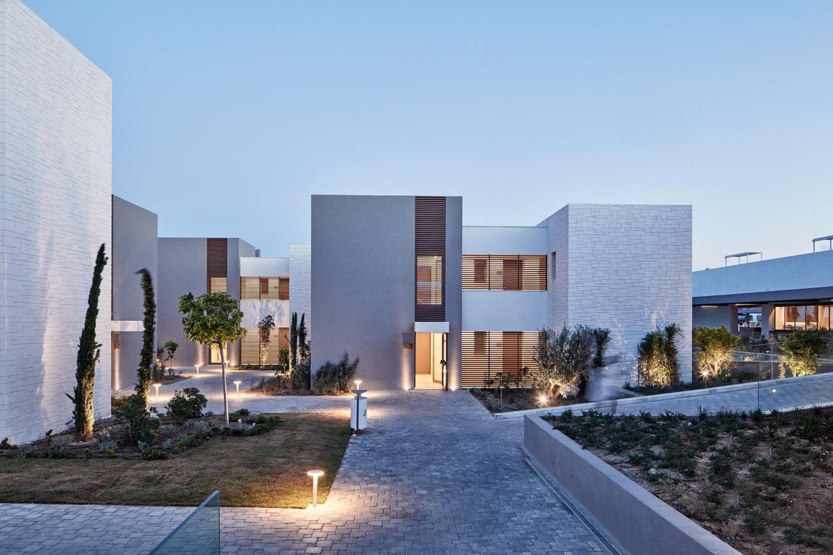 Atlantica Dreams Resort modernie numuru korpusi ar akmens apdari un labiekārtotu teritoriju vakarā, Rodas sala, Grieķija