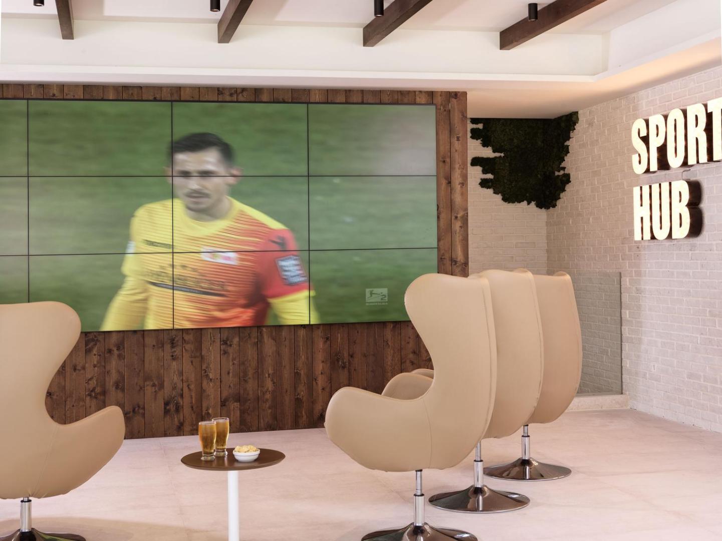 Atlantica Dreams Resort sporta bārs Sport Hub ar lielu ekrānu futbola translācijām un ērtiem atpūtas krēsliem Rodas salā