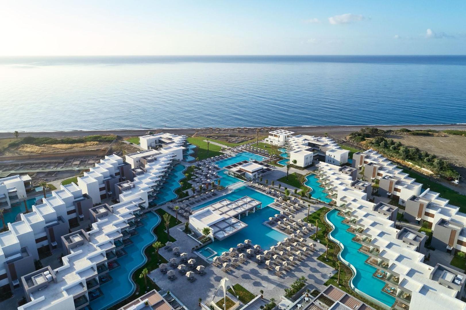 Atlantica Dreams Resort Rodā aerofoto ar skatu uz baseinu kompleksu, numuriem ar piekļuvi baseinam un oļu pludmali pie Vidusjūras