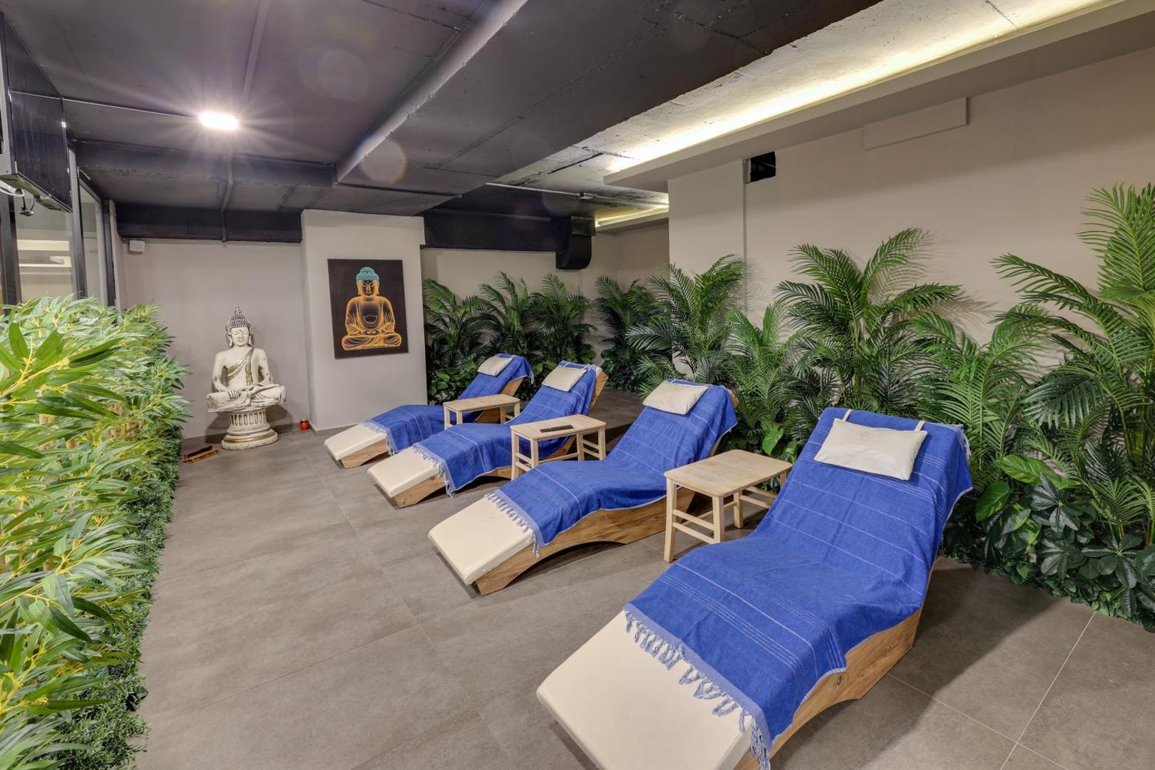 Diamond of Bodrum Hotel spa atpūtas telpa ar ziliem zviļņiem, Budas tēliem un dekoratīviem augiem mierīgai relaksācijai