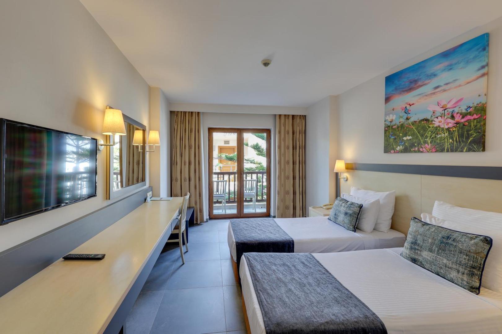 Diamond of Bodrum Hotel numurs ar divām atsevišķām gultām, balkonu, garu darba virsmu, televizoru un dabas motīvu gleznu