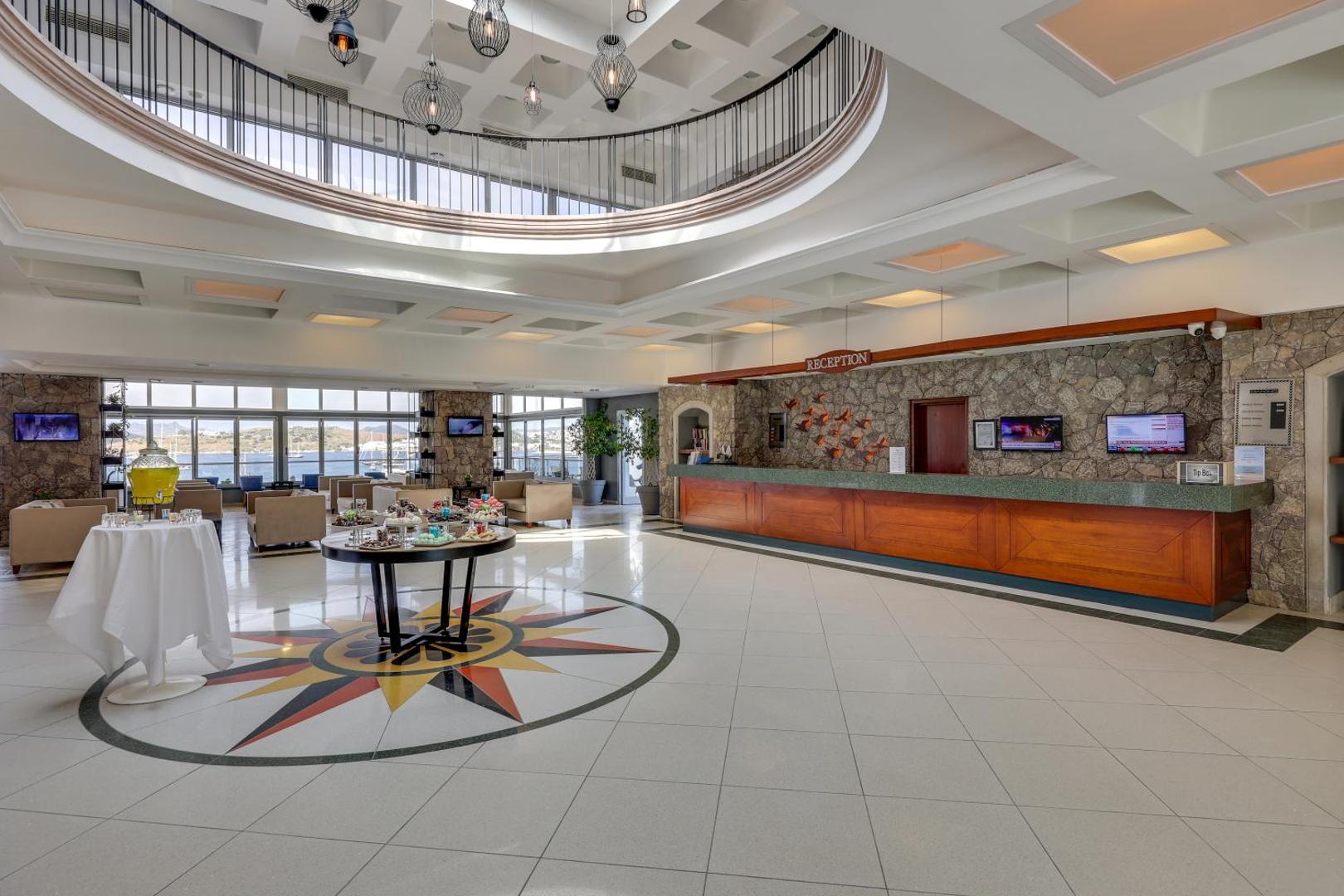 Diamond of Bodrum Hotel plašais lobby un recepcijas zona ar dekoratīvu grīdas mozaīku un skatu uz jūru fonā