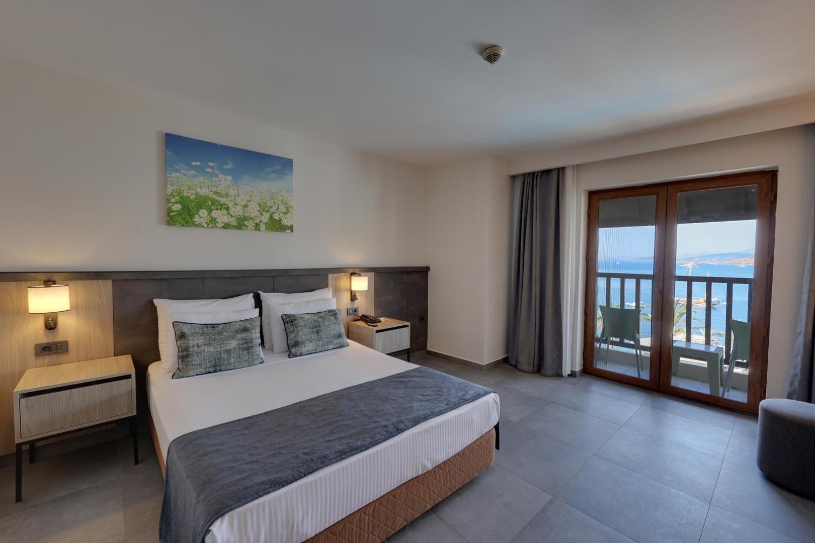 Diamond of Bodrum Hotel gaišs divvietīgs numurs ar balkonu, skatu uz jūru, modernām mēbelēm un ziedu gleznu pie sienas