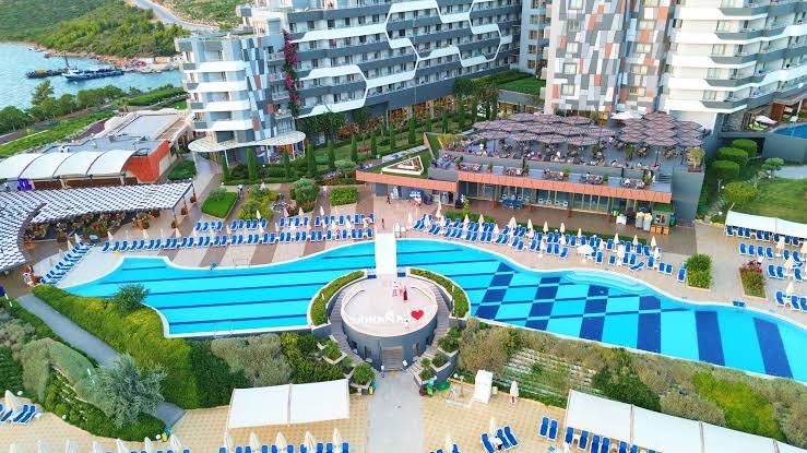 La Blanche Island Bodrum viesnīcas ēka un galvenais baseins no augšas, plaša teritorija ar atpūtas zonām un restorānu terasēm