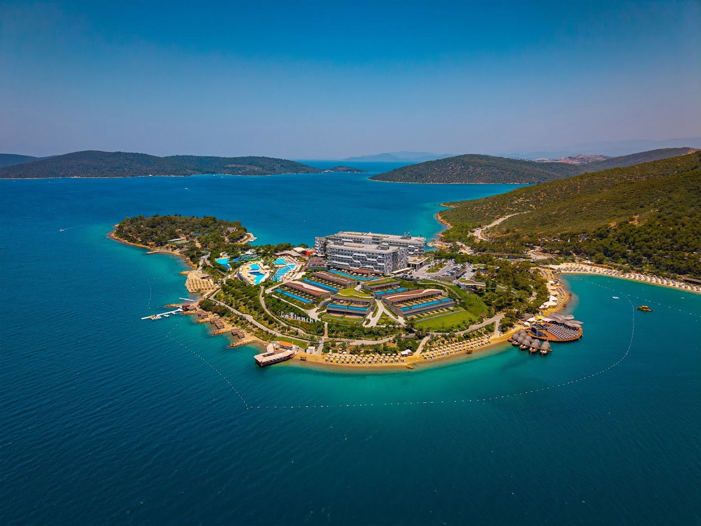 La Blanche Island Bodrum kūrorta kopskats uz pussalas ar baseiniem, pludmali un apkārtējiem kalniem Egejas jūras reģionā
